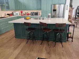 Refinished green kitchen cabinets with white countertops and wood flooring in Scottsdale, AZ