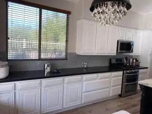 Refinished white kitchen cabinets with subway tile backsplash and stainless appliances in Phoenix, AZ