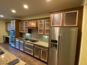 Kitchen cabinets prepped with plastic for refinishing project