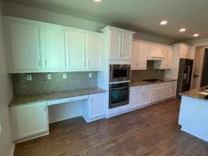 Bright kitchen with freshly painted white cabinets and granite countertops