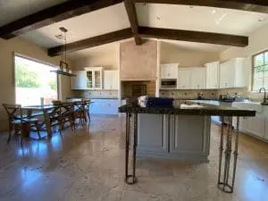 Refinished white kitchen cabinets with dark island and exposed ceiling beams in Cave Creek, AZ